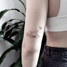 a woman's arm with a small tattoo of a mouse and a butterfly on it