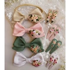 several different types of hair clips on a white lace doily with flowers and leaves