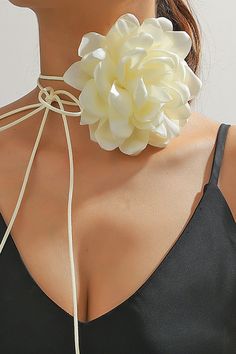 a woman wearing a white flower necklace on her neck