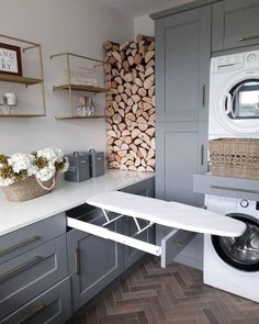 a washer and dryer in a small room with wood stacked on the wall