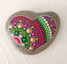 a painted rock in the shape of a heart