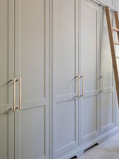 a ladder leaning up against some white cabinets