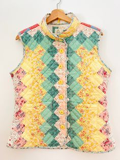 "Soft, cozy, and cuddly, with wonderful colors and textures, this vest is dopamine dressing at its finest  Crafted from a 1990s Arch quilt in an Around the World pattern. Cotton patchwork top and muslin backing, with lofty poly fill batting. Machine pieced and hand quilted  All seams and raw edges are bound with homemade bias tape, there are two front patch pockets, a cozy stand up collar, and the front panels close with a row of butter yellow vintage buttons in a fun swirl motif  A great layering garment In excellent condition with no issues whatsoever. Sturdy, durable, with nice weight and structure but no bulk. A wardrobe staple that will last for years to come!  Measurements (laying flat): Pit to pit: 20.5\" Waist: 18.5\" Hem: 22\" Armscye: 10\" Back across shoulders: 16\" Length: 27\" Vintage Patchwork Vest For Summer, Fall Quilted Cotton Vest, Vintage Quilt Vest, Spring Patchwork Cotton Vest, Retro Multicolor Cotton Vest, Quilt Vest, Quilted Vests, Dopamine Dressing, Inspired Clothes