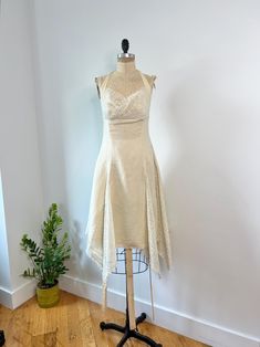 Beautiful 1960s ivory and tan lace paneled halter neck dress. This low back dress has such a beautiful asymmetrical lace paneled hem with a lace paneled bust as well, and a center back zipper closure. Some spots pictured in last few photos - in otherwise excellent vintage condition. Priced as is. B: 34" W: 29" (empire) L: ~38" front bust Bohemian Fitted Halter Evening Dress, Sleeveless Lace Dresses For Vintage Events, Beige Dresses With Fitted Bodice For Vintage Events, Beige Dress With Fitted Bodice For Vintage Events, Fitted Cream Halter Neck Dress, Cream Fitted Halter Neck Dress, Vintage White Sleeveless Lace Dress, Vintage White Halter Neck Dress, Vintage Fitted Halter Neck Dress