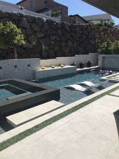 an outdoor swimming pool surrounded by stone walls