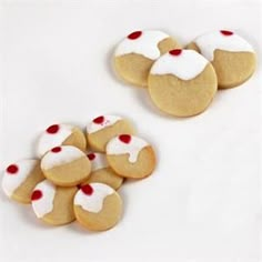 several cookies with white frosting and red sprinkles are arranged next to each other