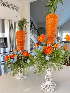 two vases filled with flowers on top of a table