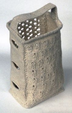 a knitted basket with holes in the front and sides, on a white background