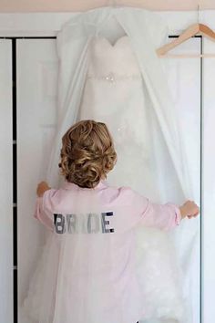 a woman standing in front of a wedding dress