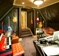 a room with guitars, piano, and other musical instruments on the wall in it