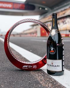 a bottle of wine sitting on the side of a race track