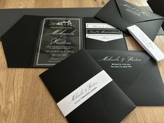 black and white wedding stationery with matching envelopes on a wooden table in front of it