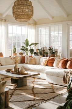 a living room filled with lots of furniture and plants on top of the couches