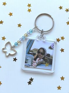 a keychain with a photo of a woman in the car and stars on it