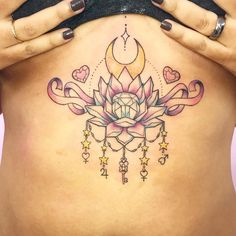 a woman's stomach with a lotus tattoo on her belly and stars around it