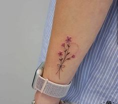 a woman's arm with a flower tattoo on the left side of her arm