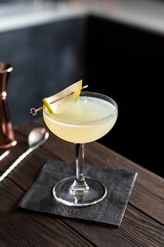 a drink in a coupe glass on a wooden table