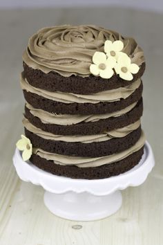 a chocolate cake with frosting and flowers on top