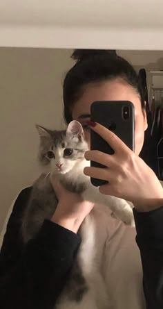 a woman taking a selfie with her cat