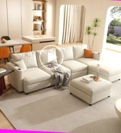 a living room filled with furniture and a large white sectional couch sitting on top of a rug