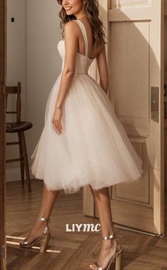 a woman standing in front of a door wearing a white dress