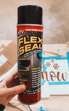 a person holding a can of fix seal next to some cut - out pieces of paper