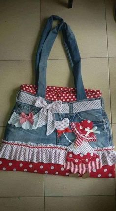 a handbag made out of jeans and fabric with bows on the front, sitting on top of a tile floor