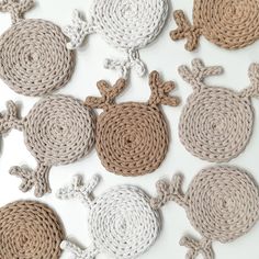 several crocheted animals are arranged on a white surface with brown and gray circles