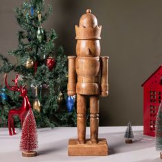 a wooden toy standing next to a christmas tree