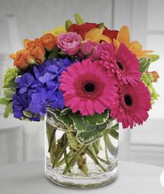 a vase filled with colorful flowers on top of a table