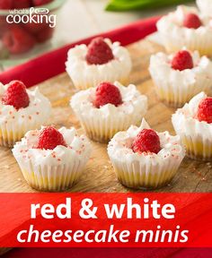 small cupcakes with white frosting and raspberries on top, sitting on a cutting board