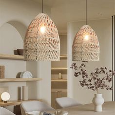 two lamps hanging over a dining room table with chairs and vases on the side