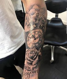 a man with a tattoo on his arm has a rose and an alarm clock in it