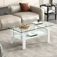 a glass coffee table sitting on top of a carpeted floor next to a couch