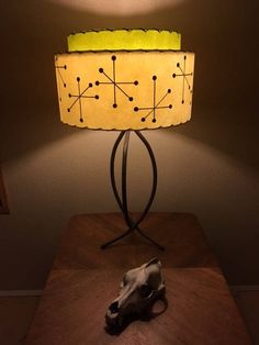 a table with a lamp on top of it and a stuffed animal under the light