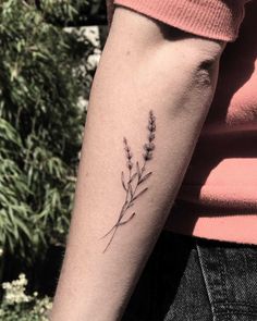 a woman's arm with a small flower tattoo on the left side of her arm