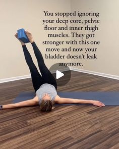 a woman is doing yoga on the floor with her hands in the air while holding a blue block