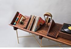 a wooden table topped with books and headphones next to a record player's turntable