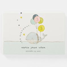 a birth card with a whale holding balloons