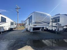 two rvs parked next to each other in a lot with no one around them