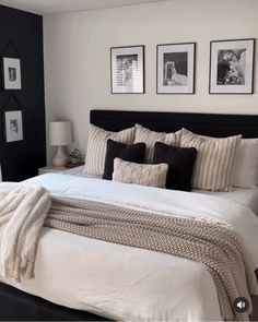 a large bed sitting in a bedroom next to two pictures on the wall above it