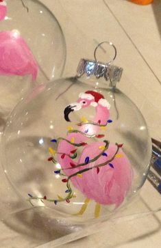 two glass ornaments with pink flamingos on them