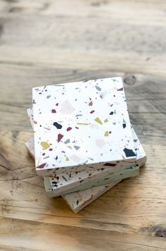 three pieces of paper sitting on top of a wooden table covered in confetti