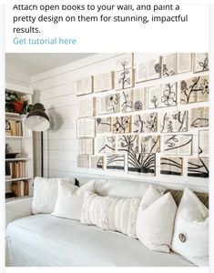 a living room with white couches and lots of books on the wall above them