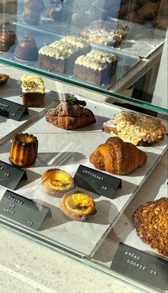 there are many different types of pastries on display in the glass case at this bakery