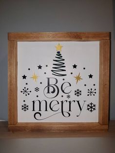 a christmas tree with the words be merry written in black and gold on white paper