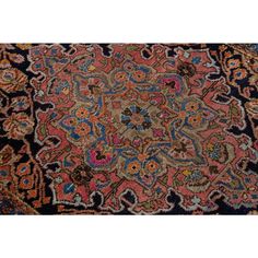 an antique persian rug with blue, pink and orange colors on the center is a floral design