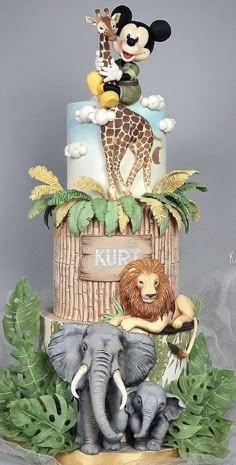 there is a cake with animals on top of it and a man riding an elephant