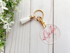 a glass keychain with the word bride written on it and a tassel