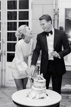 a man and woman cutting a cake together